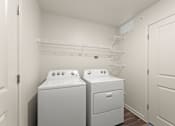 Thumbnail 24 of 39 - A laundry room with two washing machines and a shelf above them.