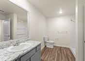 Thumbnail 20 of 39 - A bathroom with a marble countertop and wooden flooring.