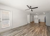 Thumbnail 13 of 39 - A room with a ceiling fan and wooden flooring.