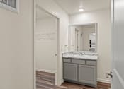 Thumbnail 21 of 39 - A bathroom with a marble countertop and a large mirror.