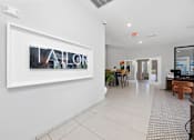 Thumbnail 81 of 83 - A hallway with a white wall and a framed picture with the word "AHOR" on it.