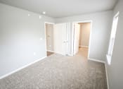 Thumbnail 23 of 25 - A room with white walls and a carpeted floor.