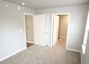 Thumbnail 20 of 25 - A room with a carpeted floor and two open doors.