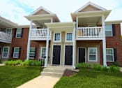 Thumbnail 41 of 43 - A two-story house with a black front door and white railings.