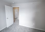 Thumbnail 18 of 43 - A room with a white door and carpeted floor.