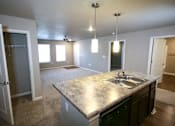 Thumbnail 11 of 25 - A kitchen with a granite countertop and a sink.