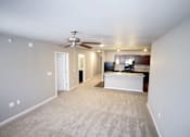 Thumbnail 9 of 25 - A living room with a television and a ceiling fan.
