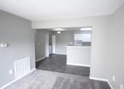 Thumbnail 5 of 11 - Empty living room with a kitchen in the background at Canterbury House apartments in Logansport, Indiana