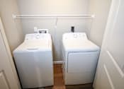 Thumbnail 19 of 25 - Two white washing machines in a small room.