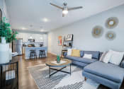 Thumbnail 21 of 42 - a living room with a couch coffee table and a kitchen in the background