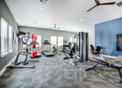 Thumbnail 11 of 42 - Fitness room with a weight machine, a bench, and cardio equipment at Aurora Apartments in Madison, Alabama