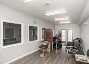 Thumbnail 8 of 21 - A room with a brown chair and a black chair.