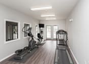 Thumbnail 7 of 21 - A spacious home gym with treadmills and elliptical machines.