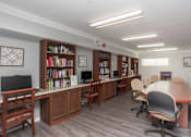 Thumbnail 12 of 21 - A room with a desk, chairs, and bookshelves.