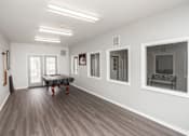 Thumbnail 11 of 21 - A spacious room with a table and chairs in the center.