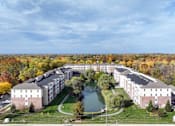 Thumbnail 4 of 21 - A large building complex with a pond in front of it.