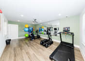 Thumbnail 32 of 35 - A home gym with a treadmill, exercise balls, and other equipment.