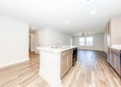Thumbnail 2 of 35 - A kitchen with wooden floors and white walls.