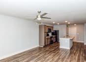 Thumbnail 5 of 35 - A room with a ceiling fan and wooden flooring.