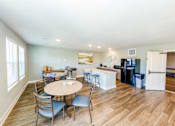 Thumbnail 27 of 35 - A kitchen with a table and chairs in the middle of the room.