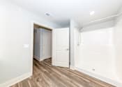 Thumbnail 14 of 35 - A white bathroom with a walk-in shower and a white door.