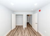 Thumbnail 19 of 35 - A room with a wooden floor and white walls, with a red fire alarm on the wall.