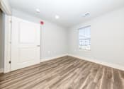 Thumbnail 17 of 35 - A room with a wooden floor and a window.