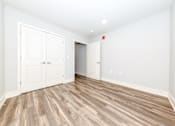 Thumbnail 13 of 35 - A room with white walls and wood flooring with a red light on the wall.