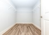 Thumbnail 18 of 35 - A room with a white door and a white ceiling with a wood floor.