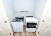 Thumbnail 23 of 35 - A small laundry room with a washer and dryer.