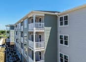 Thumbnail 35 of 35 - A grey apartment building with balconies and multiple windows.