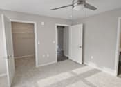 Thumbnail 12 of 24 - A room with a ceiling fan and a carpeted floor.