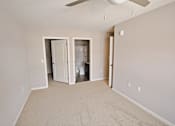 Thumbnail 11 of 24 - A room with a carpeted floor and a ceiling fan.