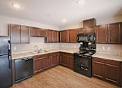 Thumbnail 1 of 24 - A kitchen with black appliances and wooden cabinets.