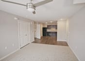Thumbnail 5 of 24 - A spacious living room with a ceiling fan and a beige carpet.