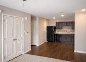Thumbnail 4 of 24 - A kitchen with a black fridge and brown cabinets.