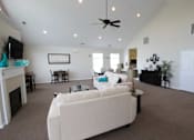 Thumbnail 7 of 15 - community living room with a white couch and a ceiling fan at canterbury apartments in kalamazoo, mi