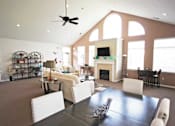 Thumbnail 6 of 15 - Community living room with a dining table and a fireplace at canterbury apartments in kalamazoo, mi