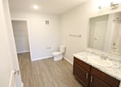 Thumbnail 18 of 25 - A bathroom with a toilet, sink, and mirror.