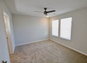 Thumbnail 17 of 25 - A room with a ceiling fan and two windows