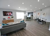 Thumbnail 5 of 25 - Community living room with a grey couch and a television on the wall at Cobalt apartments in Kokomo, In