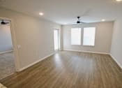 Thumbnail 15 of 25 - A room with a ceiling fan and wood flooring.