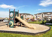 Thumbnail 12 of 31 - Playground with a slide and clock in front of Mosaic Apartments in Avon, Indiana