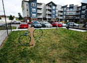 Thumbnail 30 of 34 - A playground with a swing set in front of apartment buildings.