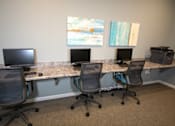 Thumbnail 5 of 25 - Three chairs are placed in front of three computers.