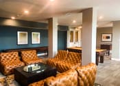 Thumbnail 9 of 22 - The community clubhouse with couch and table at The Lofts at Canterbury in Slidell, Louisiana