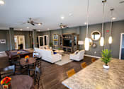 Thumbnail 4 of 25 - A living room with a dark wood floor and furniture.
