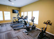 Thumbnail 3 of 25 - A room with a yellow wall and a treadmill.