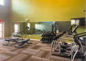 Thumbnail 11 of 22 - Fitness center with weights, weight bench, and ellipticals at The Lofts at Canterbury in Slidell, Louisiana