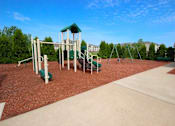 Thumbnail 13 of 15 - a childrens playground with a green swing set at Canterbury apartments in Kalamazoo, MI